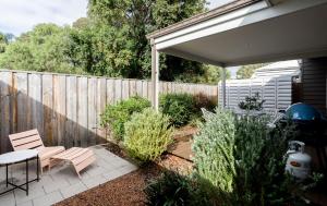 a patio with a table and chairs and a fence at Villa Marlee Margaret River in Margaret River Town