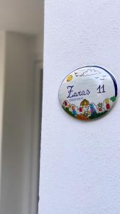 um sinal no lado de uma parede branca em Zaras 11 em Ischia