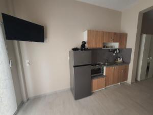 a small kitchen with a stove and a refrigerator at New apartment ,50m from the sea at Nea Irakleia. in Nea Irakleia