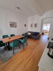 uma sala de estar com uma mesa de madeira e cadeiras verdes em Vienna Experience em Viena mais 37 fotografias