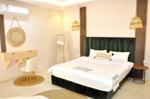 1 dormitorio con 1 cama grande y cabecero verde en مساكن الدار 9 en Abha