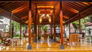 a pavilion with tables and chairs and a chandelier at Kutus Kutus Omah Siliran Heritage in Yogyakarta