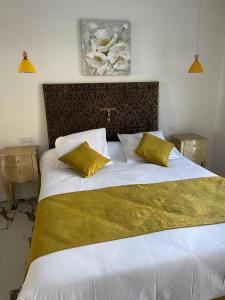 a bedroom with a large white bed with two yellow pillows at A CASA DI JO in Calenzana