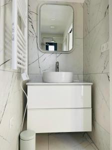 een witte badkamer met een wastafel en een spiegel bij A CASA DI JO in Calenzana