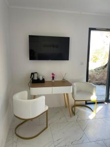 a living room with a tv and a table and chairs at A CASA DI JO in Calenzana