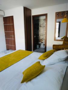 a bedroom with a large white bed with yellow pillows at A CASA DI JO in Calenzana