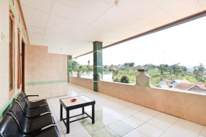 a room with a bench and a table and a window at Abang Hotel Ciwidey in Ciwidey