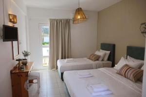 ein Hotelzimmer mit 2 Betten und einem TV in der Unterkunft Elea Terra Hotel in Matala
