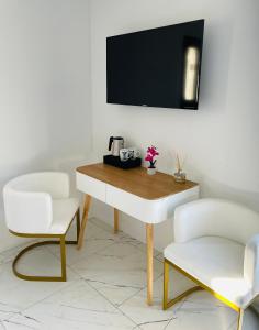 a table with two chairs and a television on a wall at A CASA DI JO in Calenzana