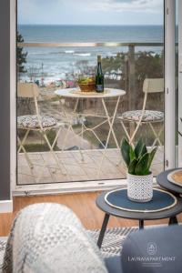 a patio with a table and chairs and a view of the ocean at Laurasapartment in Jarosławiec
