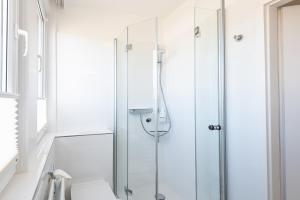 un bagno con doccia con porta in vetro di Haus Nordseegruss, App 4 a Wenningstedt Altre 9 foto