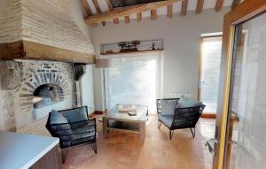 a living room with chairs and a stone fireplace at Le Petit Pavillon in Cheverny