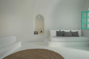 a white living room with a white couch with pillows at Sophia Castle View in Oia