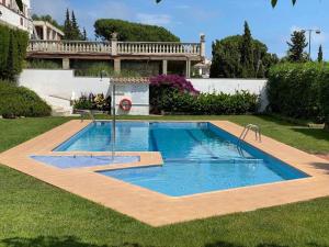 a swimming pool in the middle of a yard at Casa Blanca 42 – Piscina, BBQ y Wifi (5 pax) in Tossa de Mar
