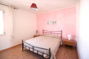 een slaapkamer met een bed en een roze muur bij Casa Montegrappa by RENTHOUSESALENTO in San Foca