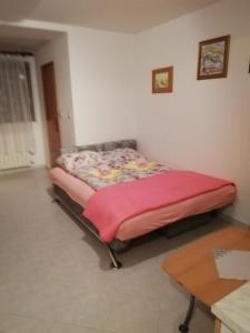 a small bed in a room with a table at Apartment Drazen in Mošćenice