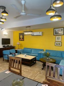 a living room with a blue couch and a table at VILLA M - JIA 3 CANDOLIM GOA 3BHK, Pool Facing, Near Beach, Free Breakfast, Free WIFI and Prime Location in Candolim