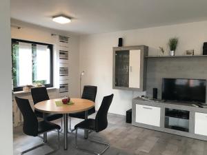 Una sala de estar con una mesa y sillas y un televisor. en Ferienwohnung Wintergarten, en Bad Pyrmont