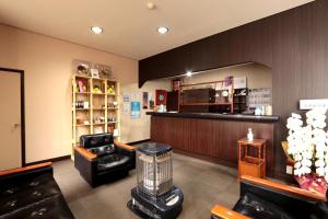 uma sala de espera com cadeiras de couro e uma barbearia em Masuya Ryokan em Izumo