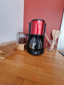 a red blender sitting on top of a wooden table at Villa avec Piscine Les Planches à Saint Valery Somme in Saint-Valéry-sur-Somme