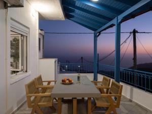 a table and chairs on a balcony with a view at Traditional House Overlooking the Libyan Sea in Kerames