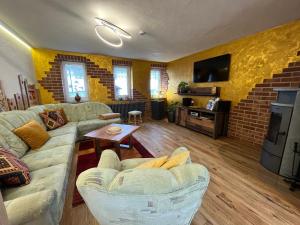 a living room with couches and a brick wall at Ferienwohnung - Haus Molle in Benneckenstein