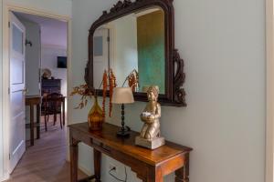 een spiegel en een standbeeld op een tafel in een kamer bij B&B De Buren in Gasselte