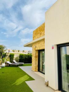 une terrasse avec une pelouse à côté d'un bâtiment dans l'établissement Luxury villa with private pool, à Rojales