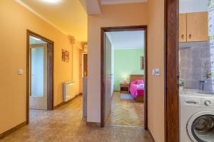a laundry room with a washing machine and a bedroom at Apartment Mirijana in Tar
