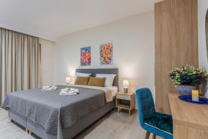 a bedroom with a bed and a blue chair at Gallery Art Apartment Chania Crete in Chania Town