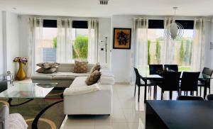 a living room with white furniture and a dining room at Luxury villa with private pool in Rojales