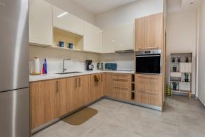 a kitchen with wooden cabinets and a stainless steel refrigerator at Gallery Art Apartment Chania Crete in Chania