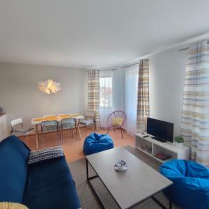 ein Wohnzimmer mit einem blauen Sofa und einem Tisch in der Unterkunft Apartament Dziwnów in Dziwnów