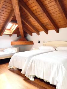 2 camas en una habitación con techos de madera en Hotel Palacio Branka en Mundaka