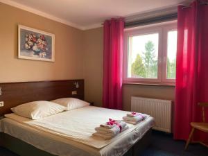 מיטה או מיטות בחדר ב-Hotelik Wulpink Majdy Olsztyn