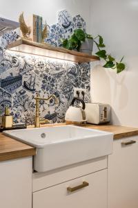 a kitchen with a white sink and a wallpaper at Chic & Comfort Homes in Central Volos # 3 in Volos +41 photos