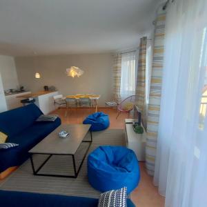 un soggiorno con divano blu e tavolo di Apartament Dziwnów a Dziwnów