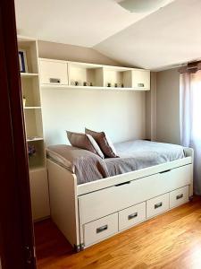 Schlafzimmer mit einem Bett mit weißen Schränken und einem Fenster in der Unterkunft VIVIENDA CORRUBEDO VISTA DUNAS in Corrubedo