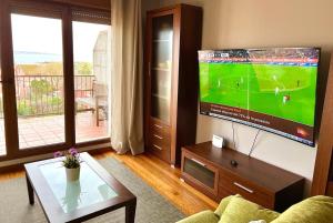 Televízia a/alebo spoločenská miestnosť v ubytovaní VIVIENDA CORRUBEDO VISTA DUNAS