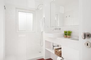 uma casa de banho branca com um lavatório e um espelho em Oporto Classic Pàtio em Porto