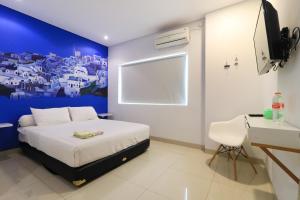 a bedroom with a bed and a blue wall at Locus Rooms in Bandung