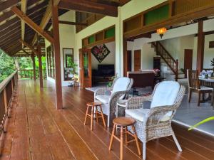 a porch of a house with chairs and a table at Alamanda Villas Langkawi in Kuah