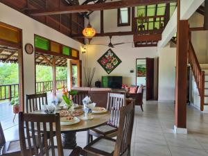 Alamanda Villas Langkawi في كواه: غرفة طعام مع طاولة وكراسي