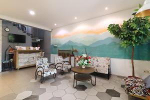 a waiting room with a painting of mountains on the wall at Locus Rooms in Bandung