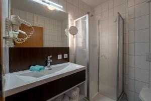 a bathroom with a sink and a shower at Hotel Nordstern in Neuharlingersiel