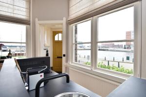 a kitchen with windows and a view of the water at Boutique Hotel Havenkantoor in The Hague