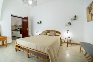 1 dormitorio con 1 cama en una habitación blanca en La Casa Di Maya, en Marsala