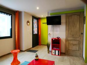 - un salon avec une porte et une table rouge dans l'établissement Au Village, à Rennes-le-Château