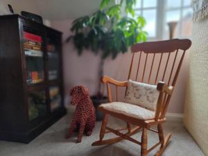 a stuffed dog sitting next to a rocking chair at Birdsong Rural Winchester Twyford - 2BR, 5BR, 7BR - sleeps upto 14 in Winchester
