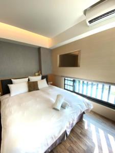 a large white bed in a room with a window at Tsang Kuo Resort in Wujie